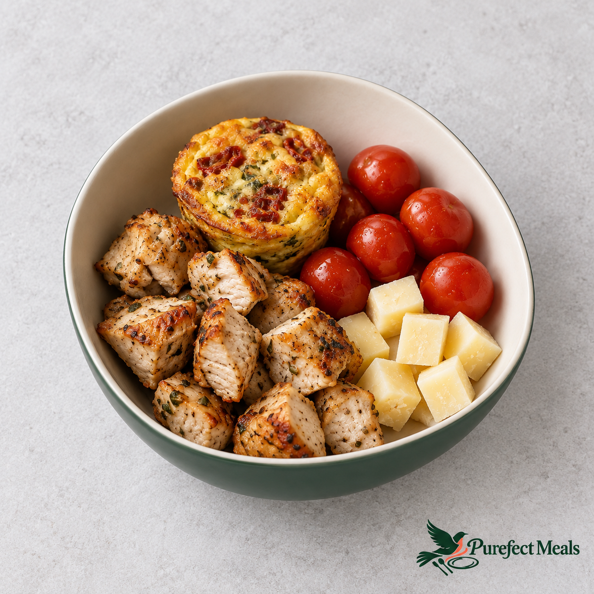 Purefect Protein Bowl with grilled chicken, sun-dried tomato mini frittata, cubed cheese and cherry tomatoes. Sun-Dried Tomatoes option shown.