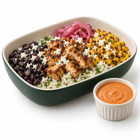 Chipotle chicken burrito bowl with pickled onions, crumbled white cheese, and reddish-orange chipotle lime crema served on the side