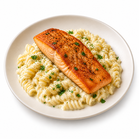 Salmon with fusilli Alfredo, fully visible ivory plate on a white background.